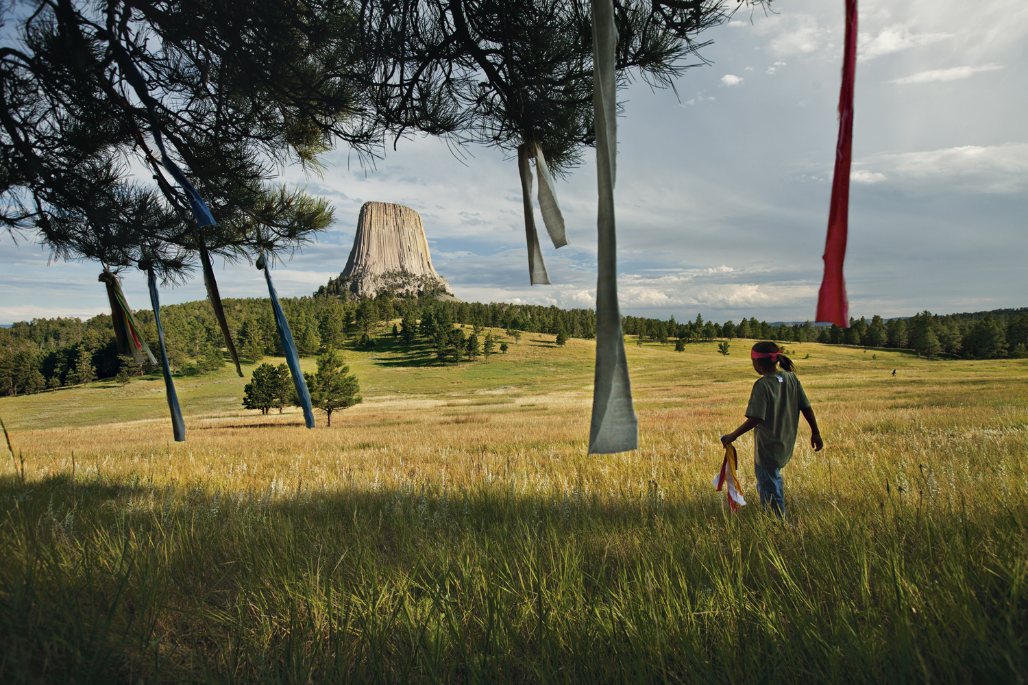 PRINT Nine-year-old Wakinyan Two Bulls places prayer flags in a tree near Mato Tipila ("bear lodge"), or Devils Tower, in Wyoming. The story of the OglalaÑtheir spirituality and their fight to remedy old wrongsÑgoes well beyond the Pine Ridge Reservation.