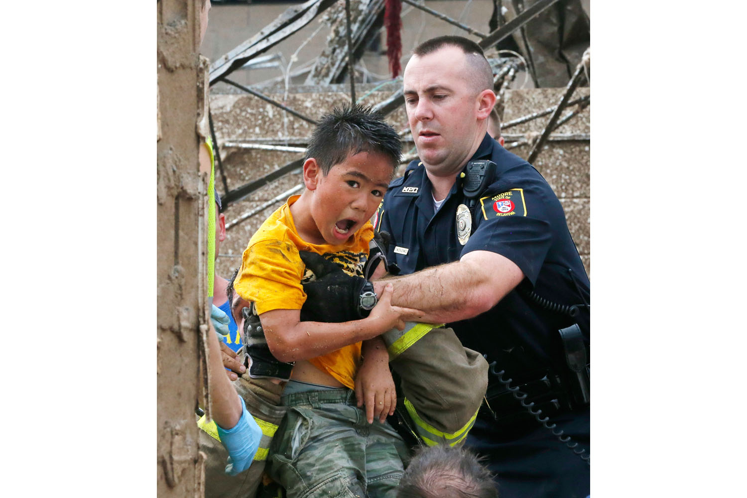 May 20, 2013. A boy is pulled from beneath a collapsed wall at the Plaza Towers Elementary School following a tornado in Moore, Okla.