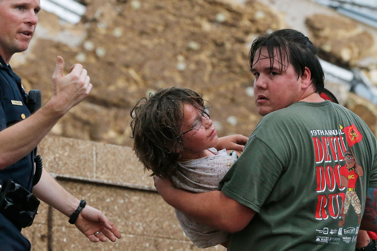 May 20, 2013. A child is carried from the rubble of the Plaza Towers Elementary School following a tornado in Moore, Okla.