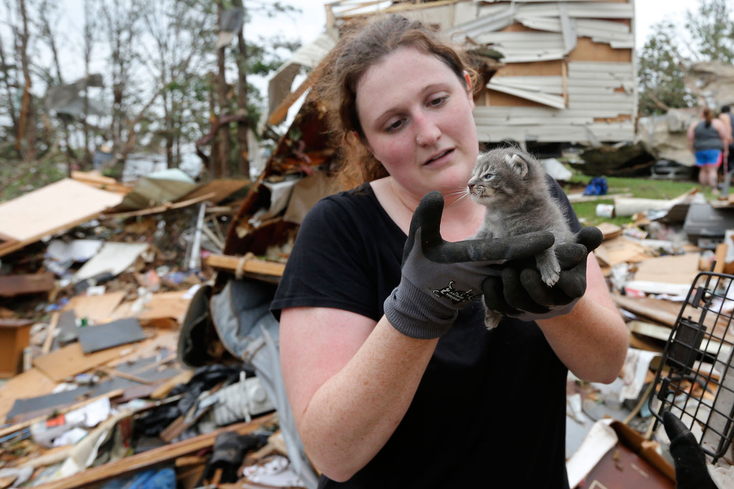 May 20, 2013. Maeghan Hadley, of One Day Ranch pet rescue, examines a kitten pulled from under the rubble of a mobile home.