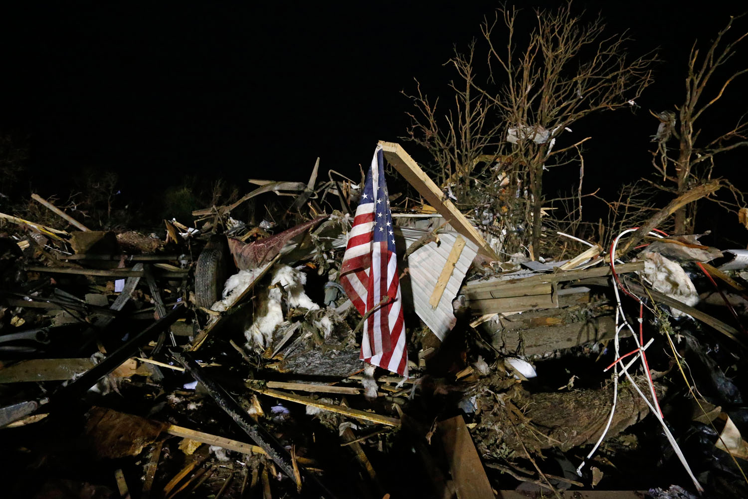 May 19, 2013. A flag flies in the debris of a mobile home after a tornado struck a mobile home park near Dale, Okla.