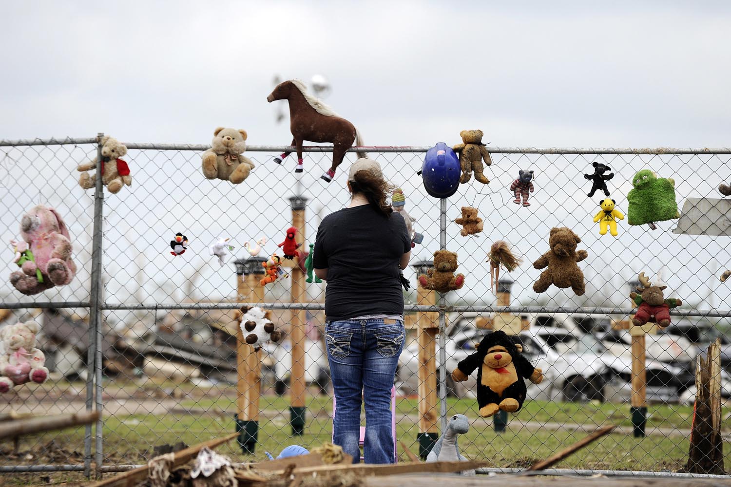 May 25, 2013. Stephanie Salinas visits a makeshift memorial with toys and crosses at the Plaza Towers elementary school in memory of the seven children who died during the devastating tornado, in Moore, Okla.
