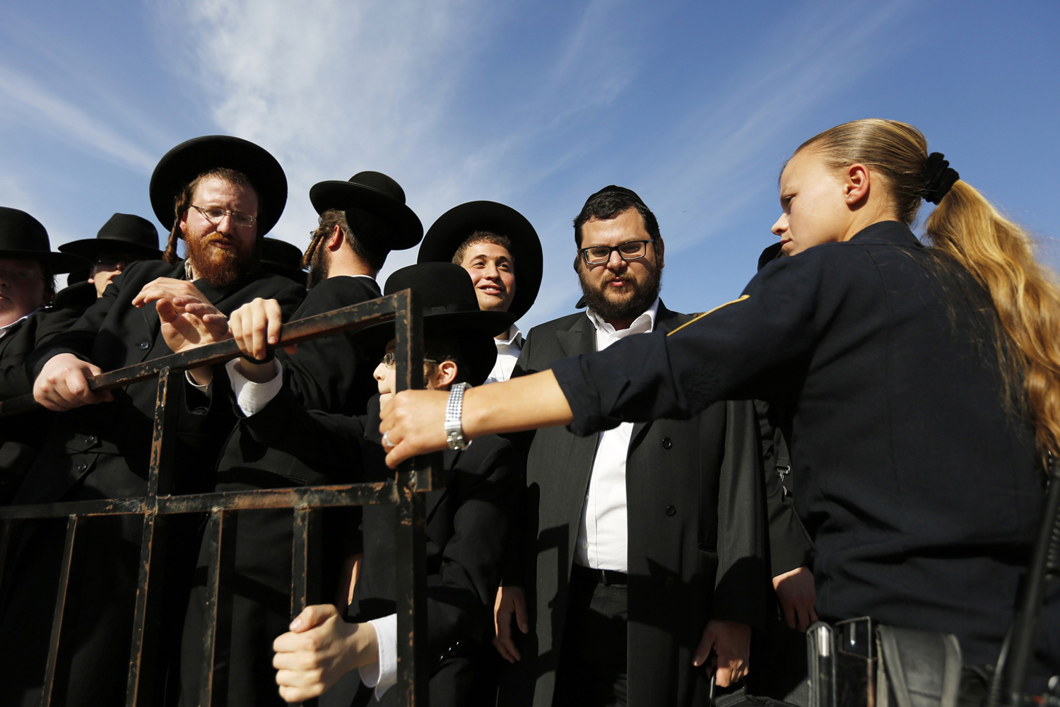 An Israeli policewoman holds back ultra-Orthodox Jewish men as they protest against the "Women of the Wall" group at the Western Wall in Jerusalem's Old City