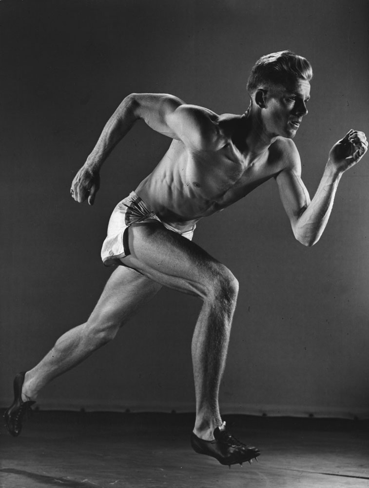 Runner photographed during an ICAAAA (Intercollegiate Association of Amateur Athletes of America) track meet, 1938.