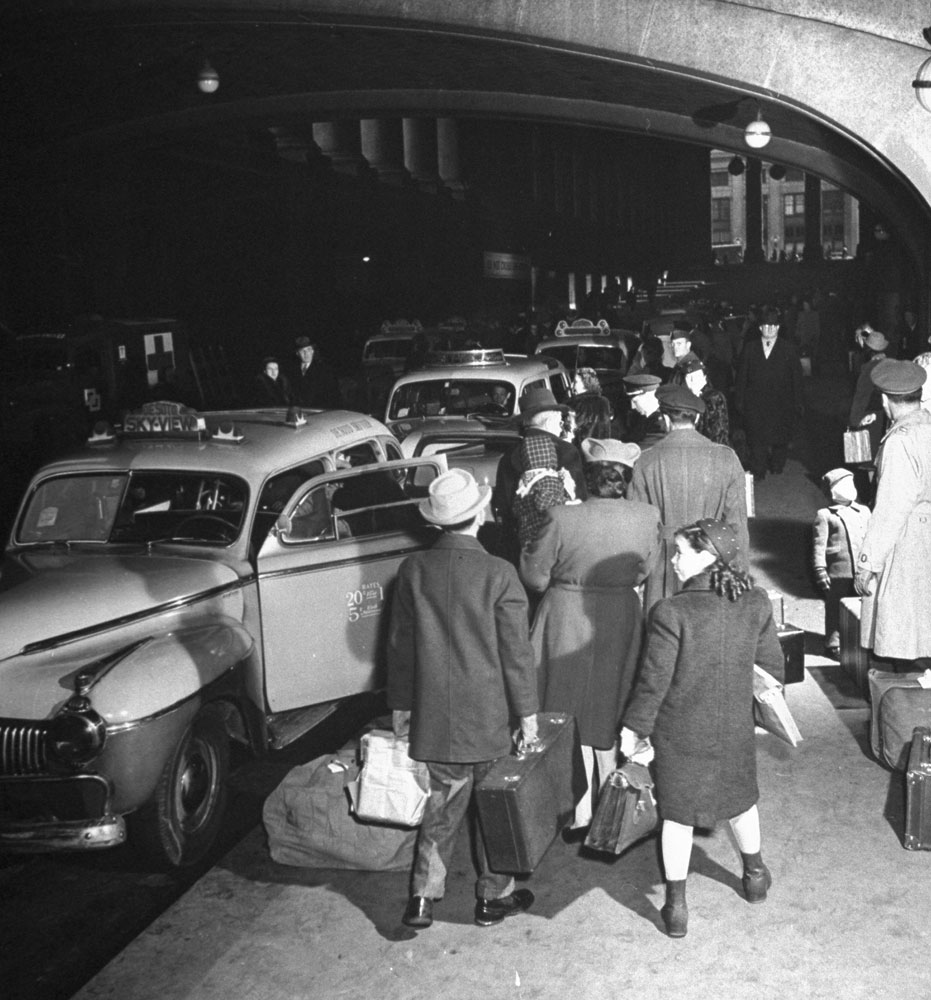 Train passengers wait to take taxi cabs outside (the original) Pennsylvania Station, New York City, 1944.
