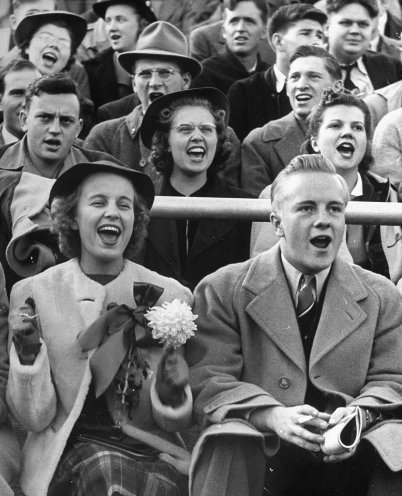 Coed Merrilyn Olson and date Brooks Conrad watching Wisconsin-Marquette football game, 1939.