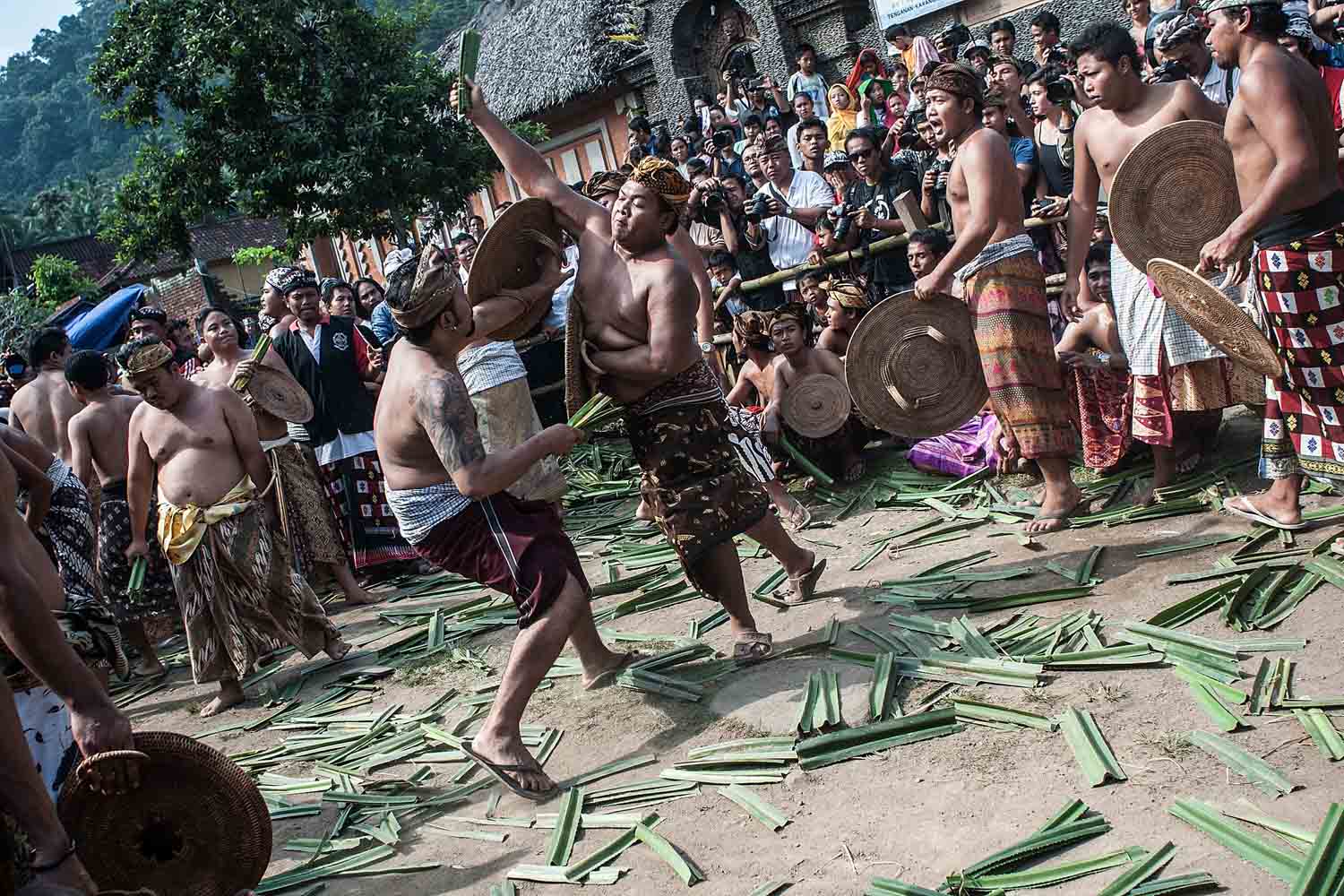June 25, 2013. Two Tengananese men fight each other using thorny pandanus leaves as part of a religious ritual in Tenganan, Karangasem, Bali, Indonesia.