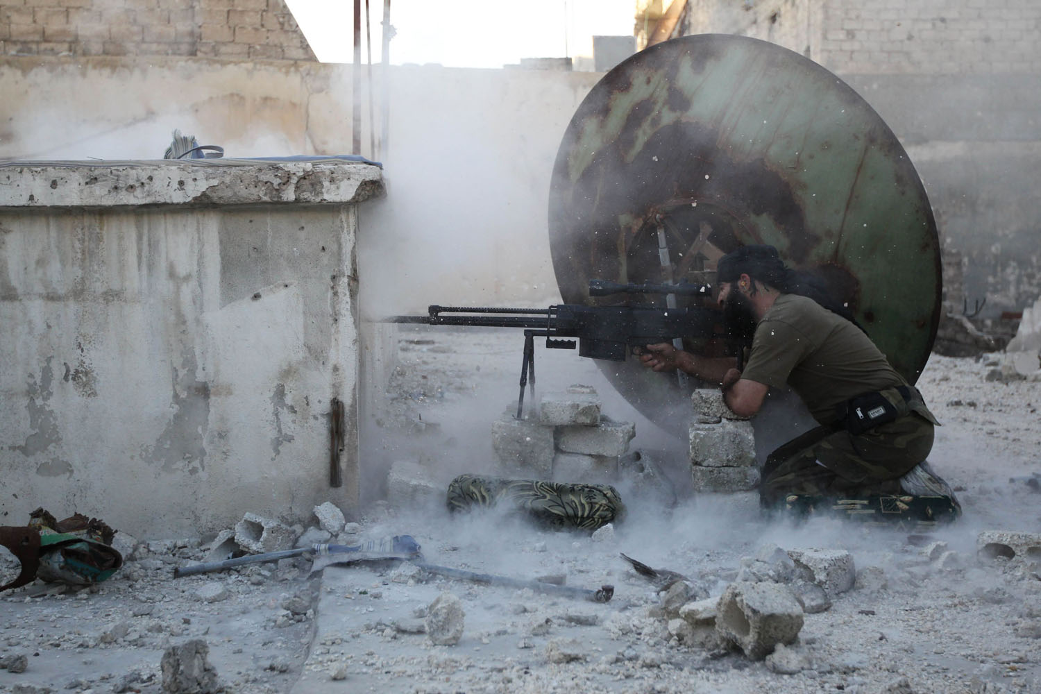 A member of the Free Syrian Army shoots back at a sniper during what activists said were clashes with pro-government forces in Aleppo's Karm al-Jabal district