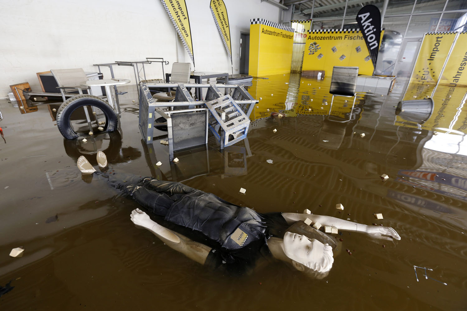 A display dummy floats in a flooded car dealership in Fischerdorf