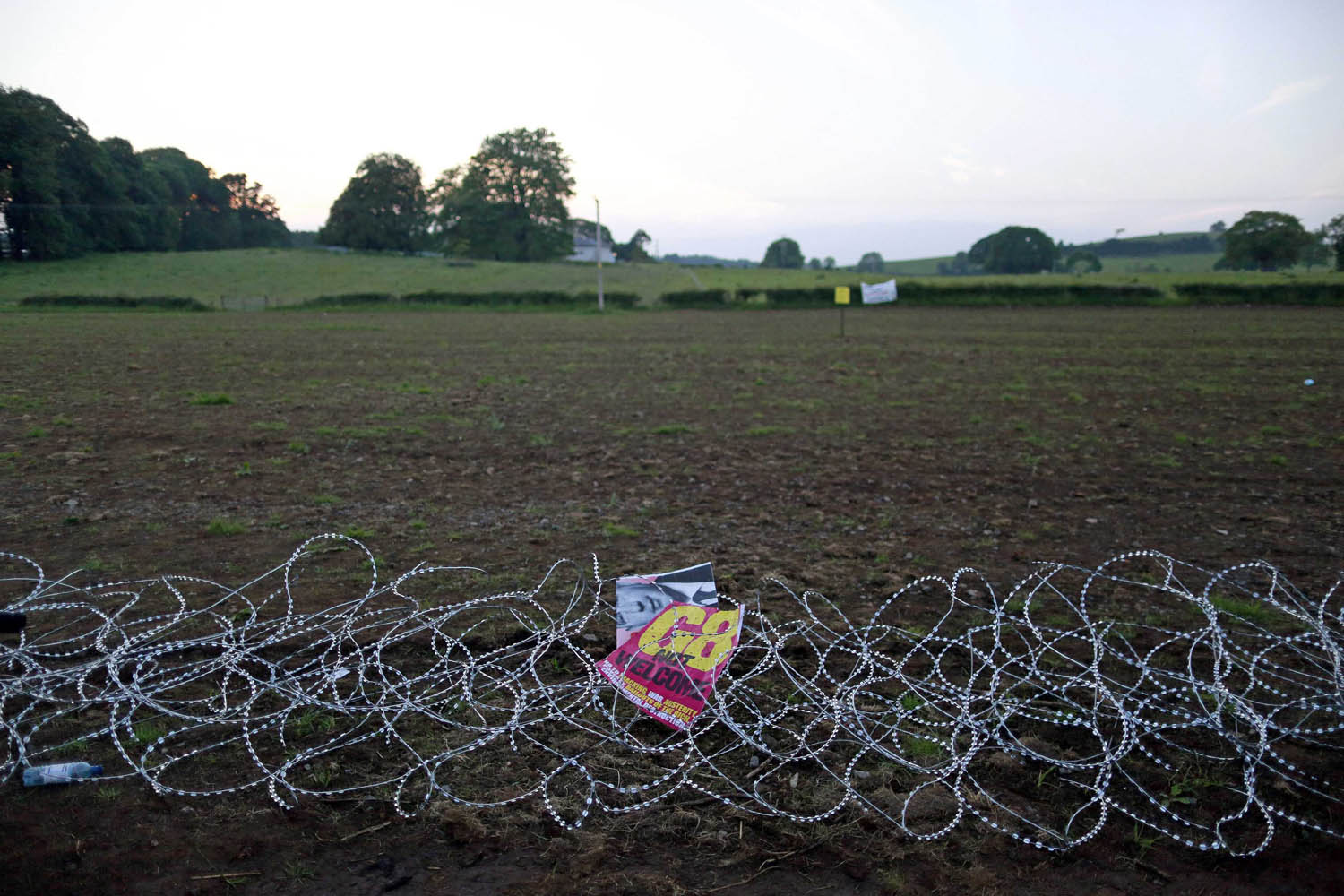 An anti-G8 poster rests in razor wire after protestors broke through the security fence surrounding the G8 Summit in the Lough Erne Golf Resort in County Fermanagh