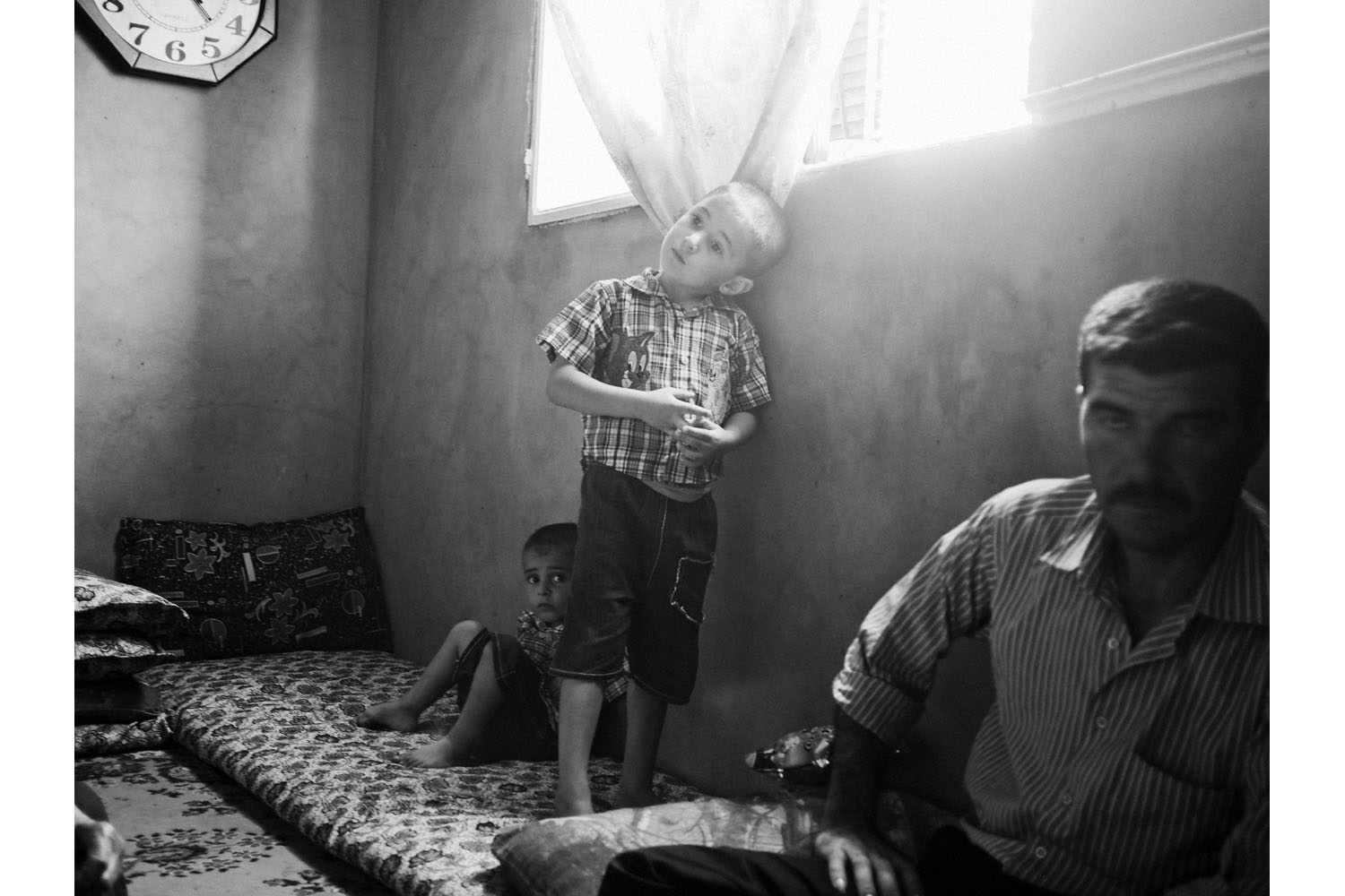 Bar-elias, Bekaa Valley, Lebanon. June 2013.6-year-old Mayar(center) with his brother and father inside their temporary home in the town of Bar-elias, Lebanon. The family is from Qusair, Syria.(Photo by Moises Saman/MAGNUM)