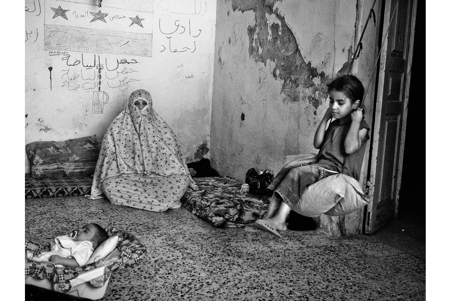 JORDAN. Amman. June 14, 2013. 9-year-old Hannen(right), sits on a swing inside her extended family's home in the Wadi Haddad district of East Amman, an area where many Syrian refugees have rented apartments. Haneen's family fled the besieged Syrian city of Homs two months ago. Her father and all the men in the family are currently in Syria fighting with the Free Syrian Army.Contact email:New York : photography@magnumphotos.comParis : magnum@magnumphotos.frLondon : magnum@magnumphotos.co.ukTokyo : tokyo@magnumphotos.co.jpContact phones:New York : +1 212 929 6000Paris: + 33 1 53 42 50 00London: + 44 20 7490 1771Tokyo: + 81 3 3219 0771Image URL:http://www.magnumphotos.com/Archive/C.aspx?VP3=ViewBox_VPage&IID=2K7O3RKN1E5S&CT=Image&IT=ZoomImage01_VForm