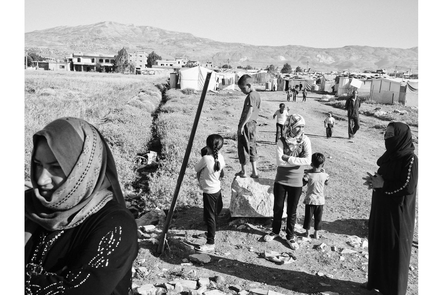Bekaa Valley, Lebanon. June 2013. Syrian refugees outside a tent settlement near the town of Bar-elias, in Lebanon's Bekaa Valley.(Photo by Moises Saman/MAGNUM)