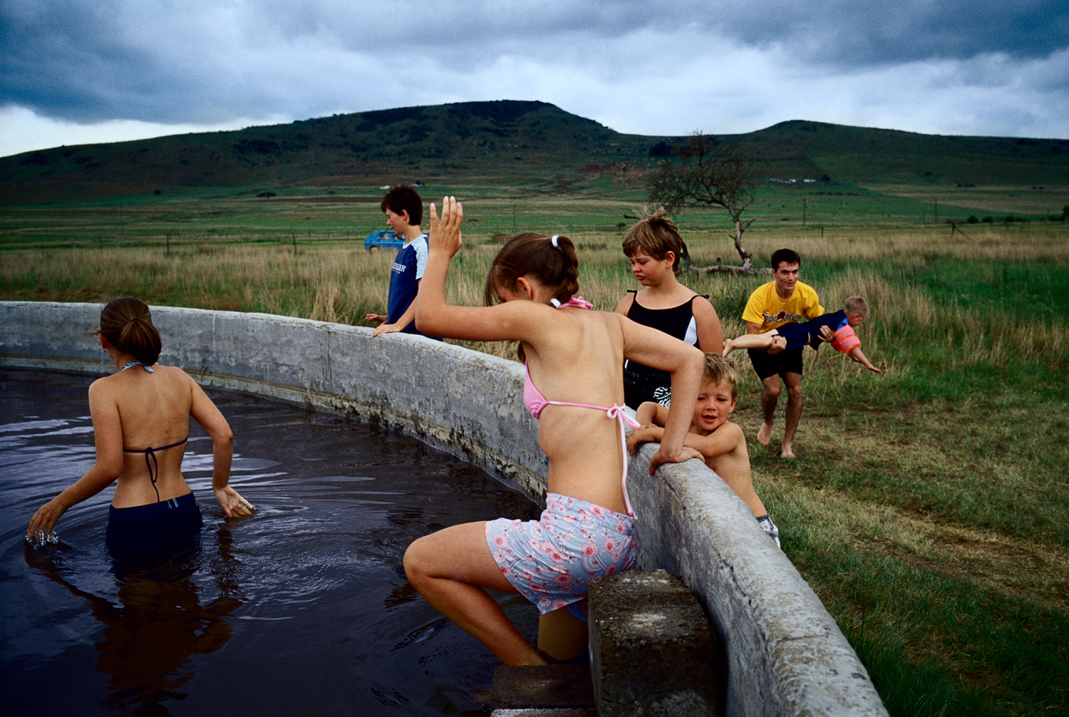 Youths bathing in a water cistern in a rural area in Blood River, Natal Province, South Africa after celebrating the battle of Blood River, December 2004. Held annually on December 16th,  the anniversary is the most important holiday in the Afrikaner calendar.