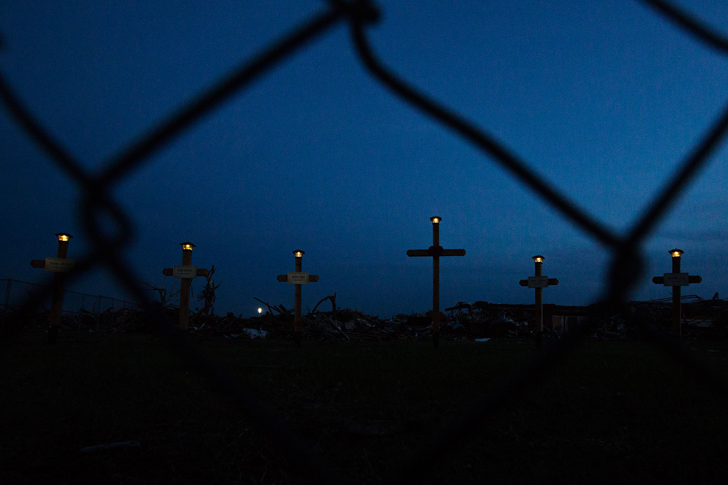 Lights shine on the tops of crosses making up a memorial outside the Plaza Towers elementary school where seven children died and several students and teachers were injured by the May 20 afternoon tornado in Moore, Oklahoma