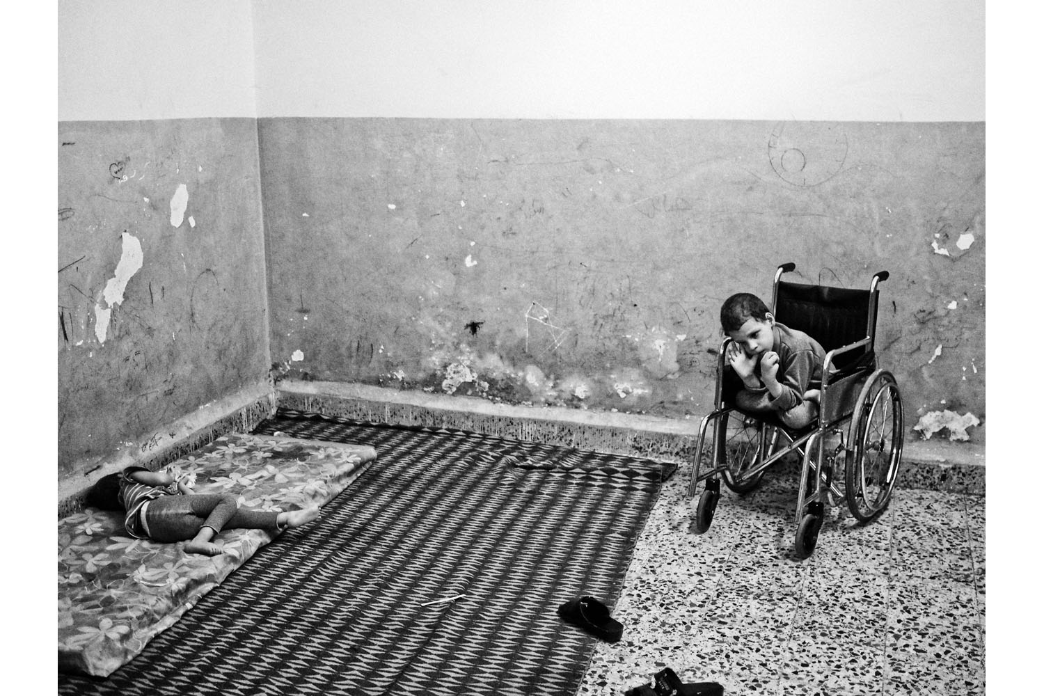 Amman, Jordan. June 2013.8-year-old Hussein(right) and his sister Firyal(left), both suffering from cerebral palsy, inside their family's one-room house in the Wadi Haddad district of East Amman, an area where a large number of Syrian refugees have settled.(Photo by Moises Saman/MAGNUM)