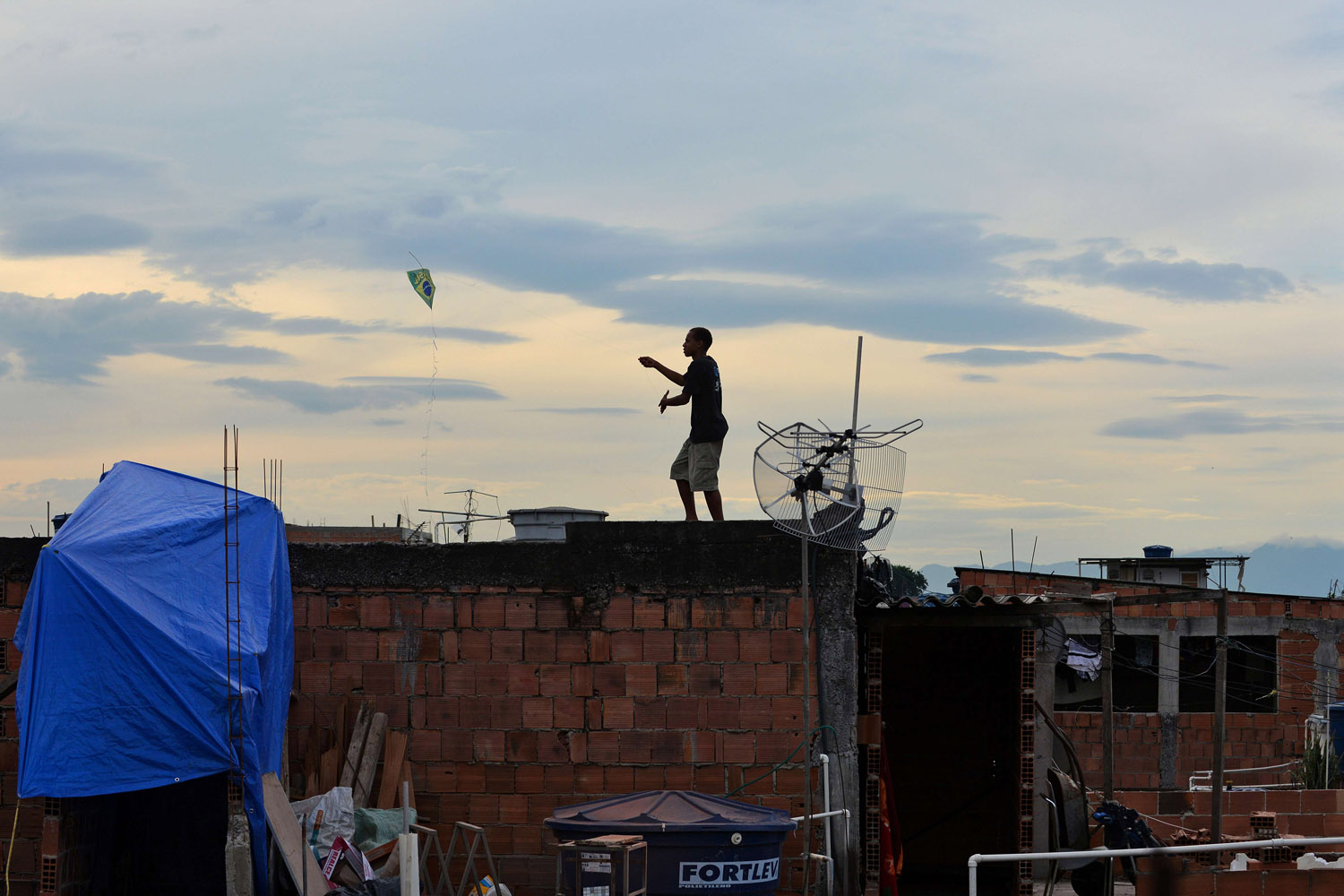 June 25, 2013. A boy flies a kite at Nova Holanda shantytown, in the violence-plagued Mare complex, a day after gun battles erupted in the slum complex in Rio de Janeiro.