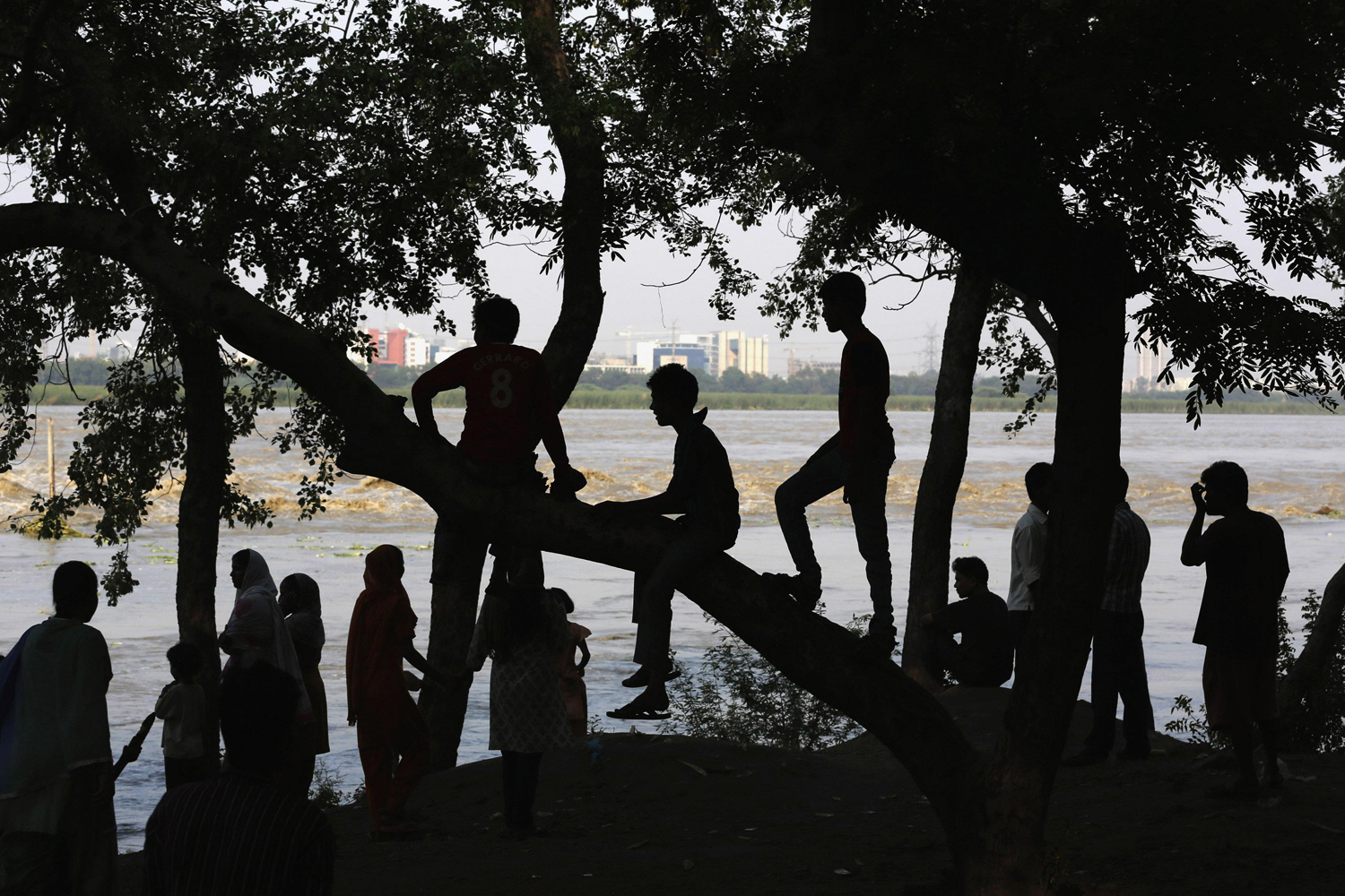 People watch the rising waters of river Yamuna in New Delhi