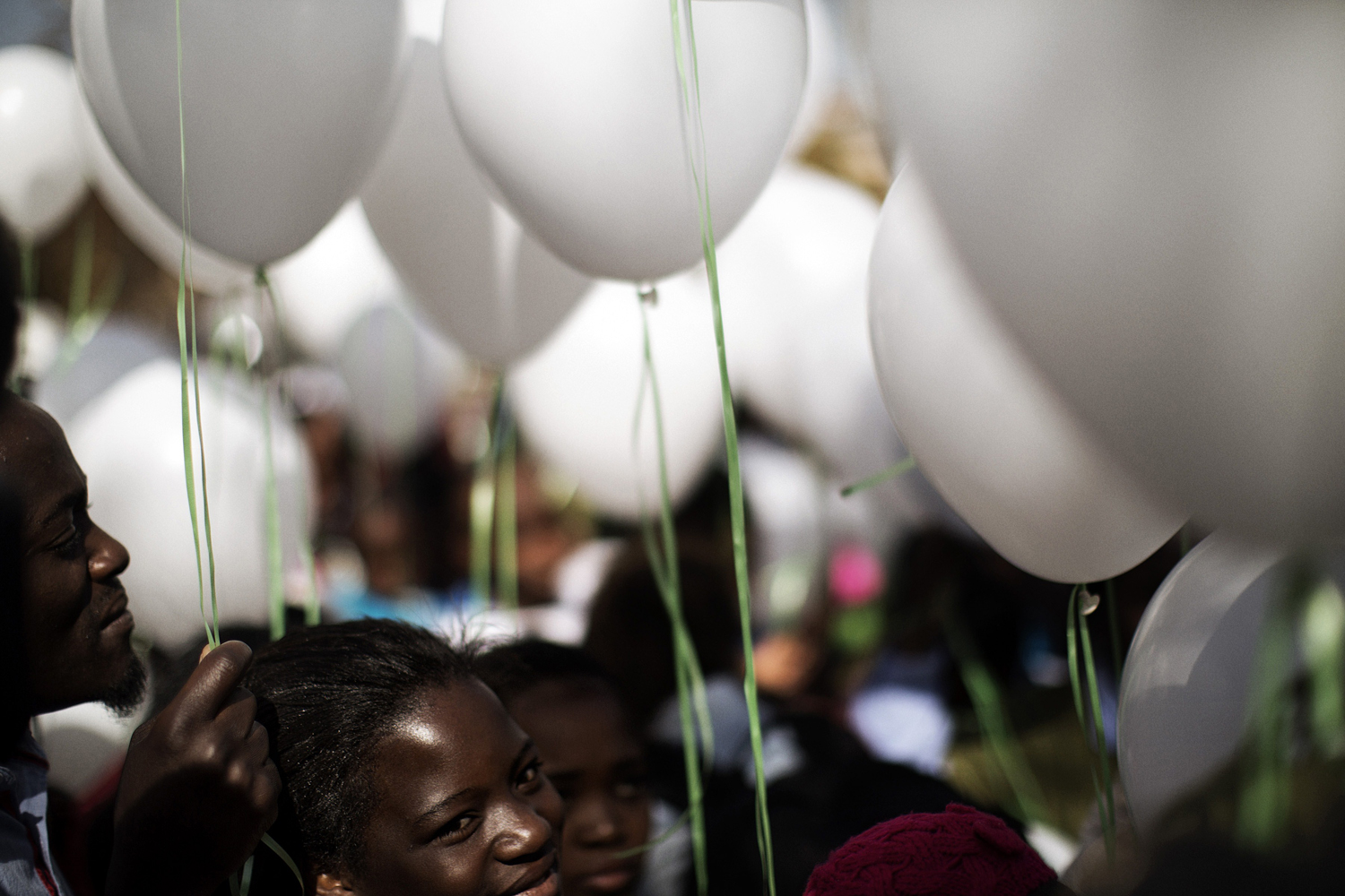 June 27, 2013. Well wishers hold 95 white balloons, one for each year of age, in honor of Nelson Mandela outside the Medi Clinic Heart Hospital in Pretoria.