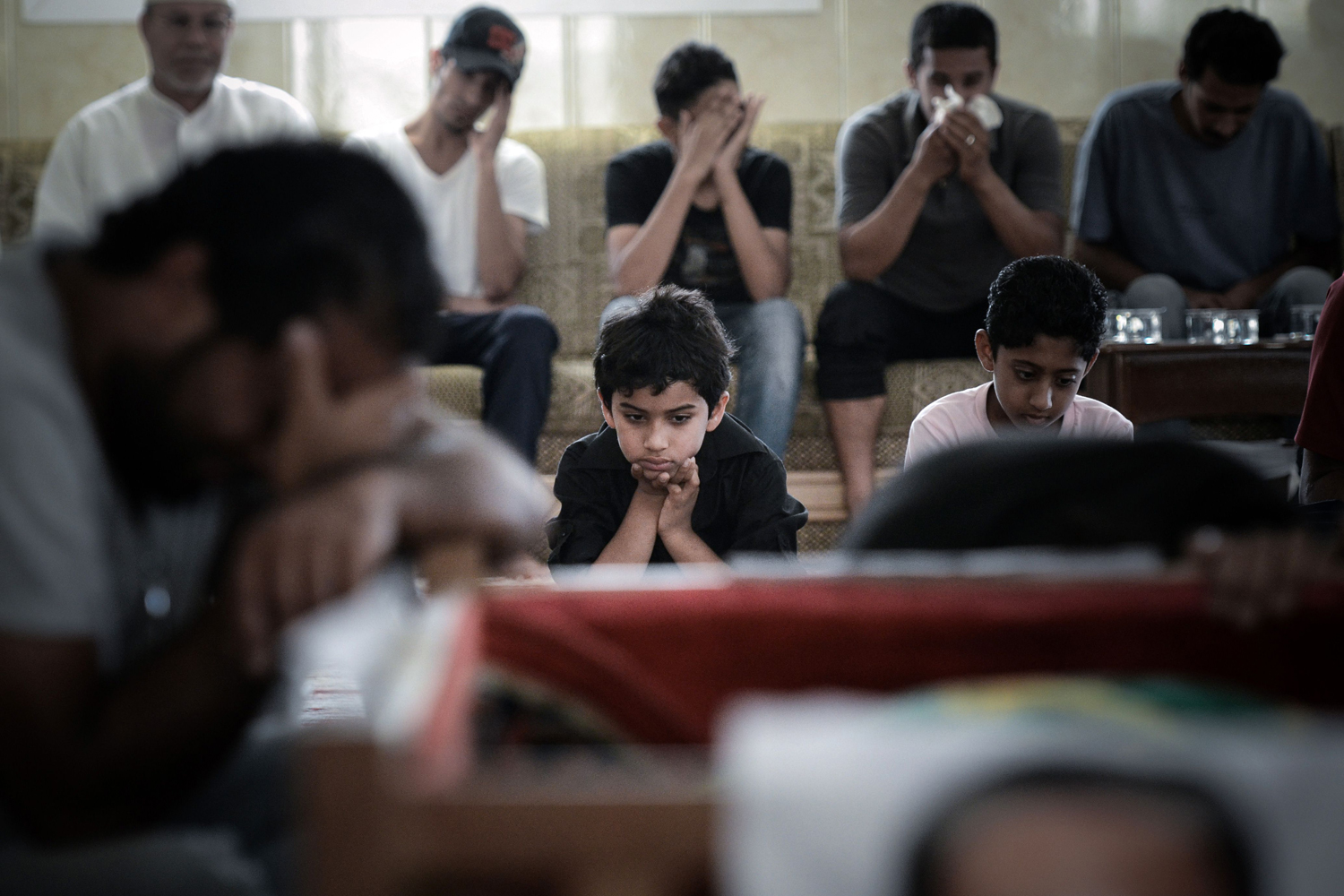 June 26, 2013. Bahraini men mourn during the funeral of Hussein Abdullah in the village of Saar, west of Manama.