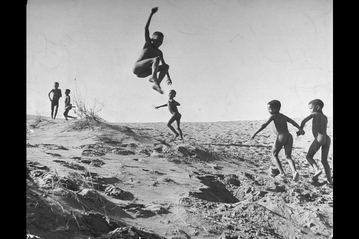 Bushman children playing games on sand dunes, 1947.