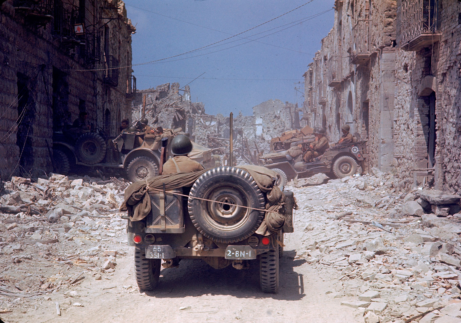 American jeeps travel through a bombed-out town during the drive towards Rome, World War II.