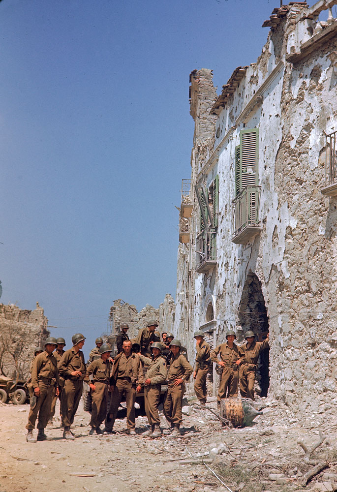 American troops stand in front of a bombed-out building during the drive towards Rome, WWII.