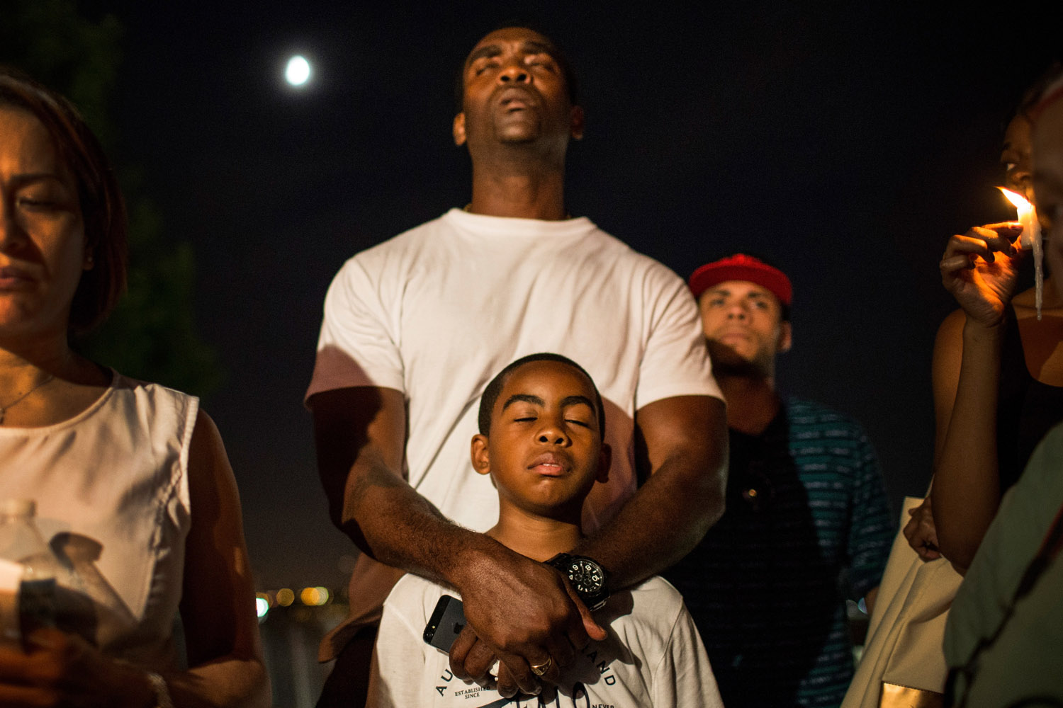 July 15, 2013. A man holds his son while participating in a candle lit vigil for Trayvon Martin, the teenager who was shot and killed in Florida last year, in New York.