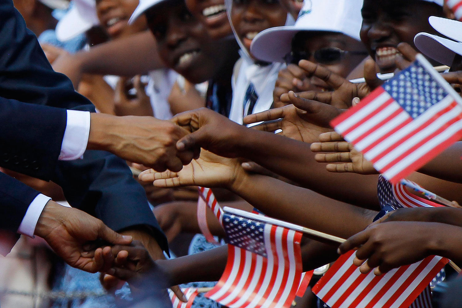 President Barack Obama shakes hands and greets Tanzanians during an official arrival ceremony in Dar Es Salaam
