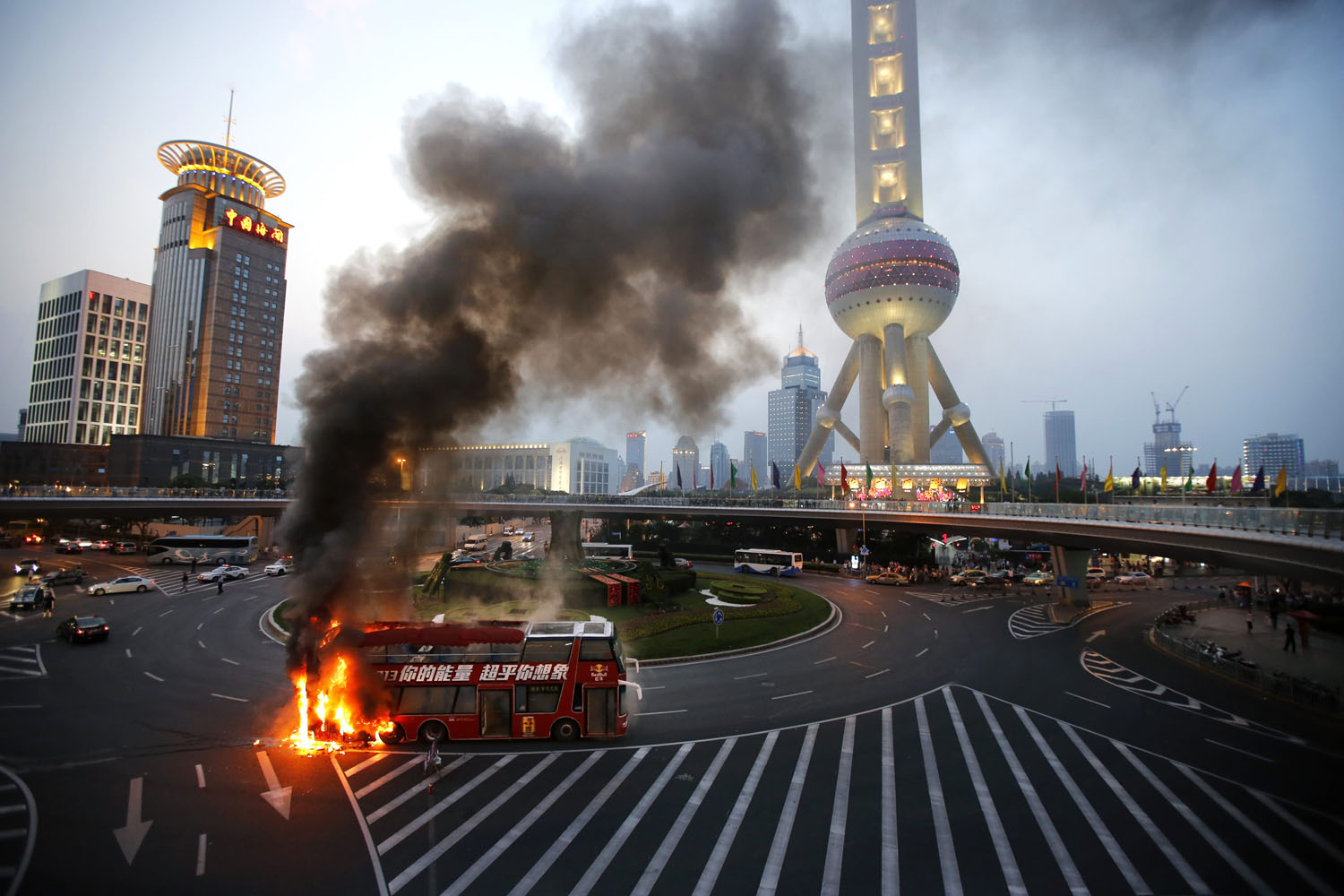 A double-decker tourism bus is seen on fire in from of the Oriental Pearl Tower in the Pudong financial district of Shanghai