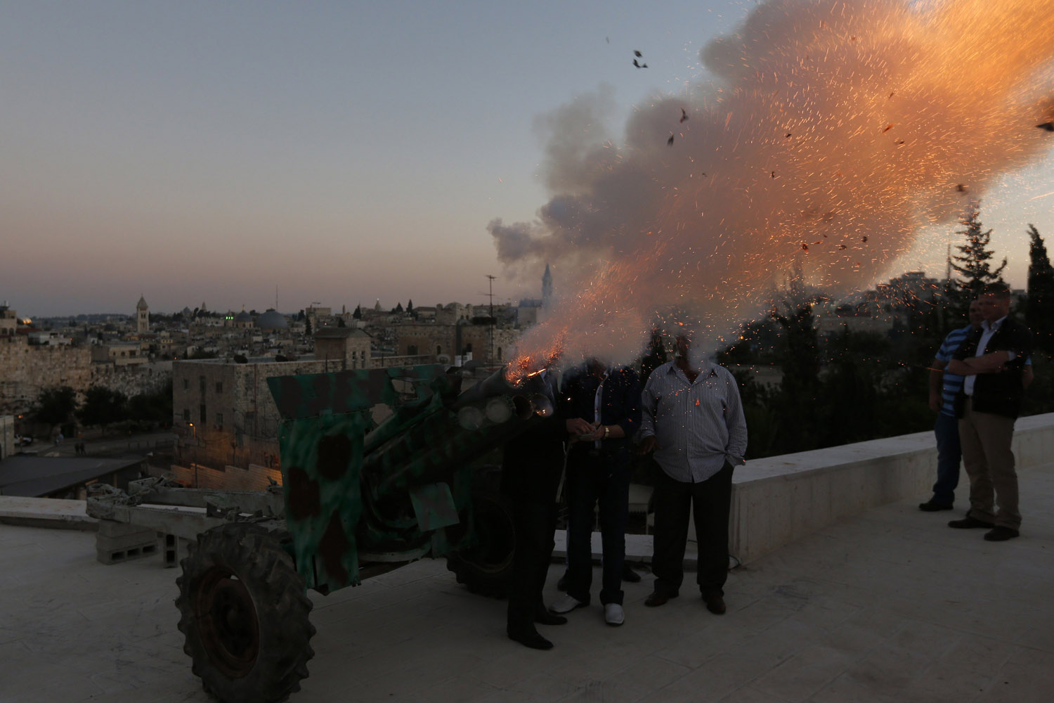 A cannon fires a ceremonial shot just outside Jerusalem's Old City, to mark the end of Muslims' daily fast during Ramadan