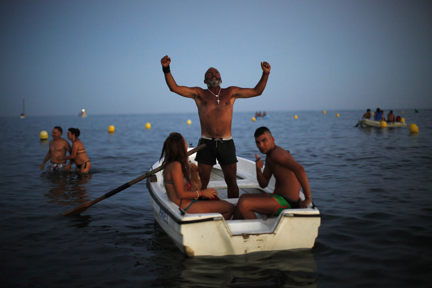 A man shouts blessings at a statue of the El Carmen Virgin after it was carried into the sea during a procession in Malaga