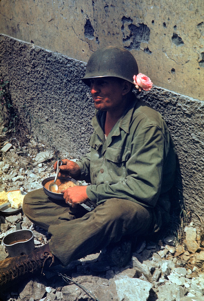 An American soldier on a meal break during the drive towards Rome, 1944.