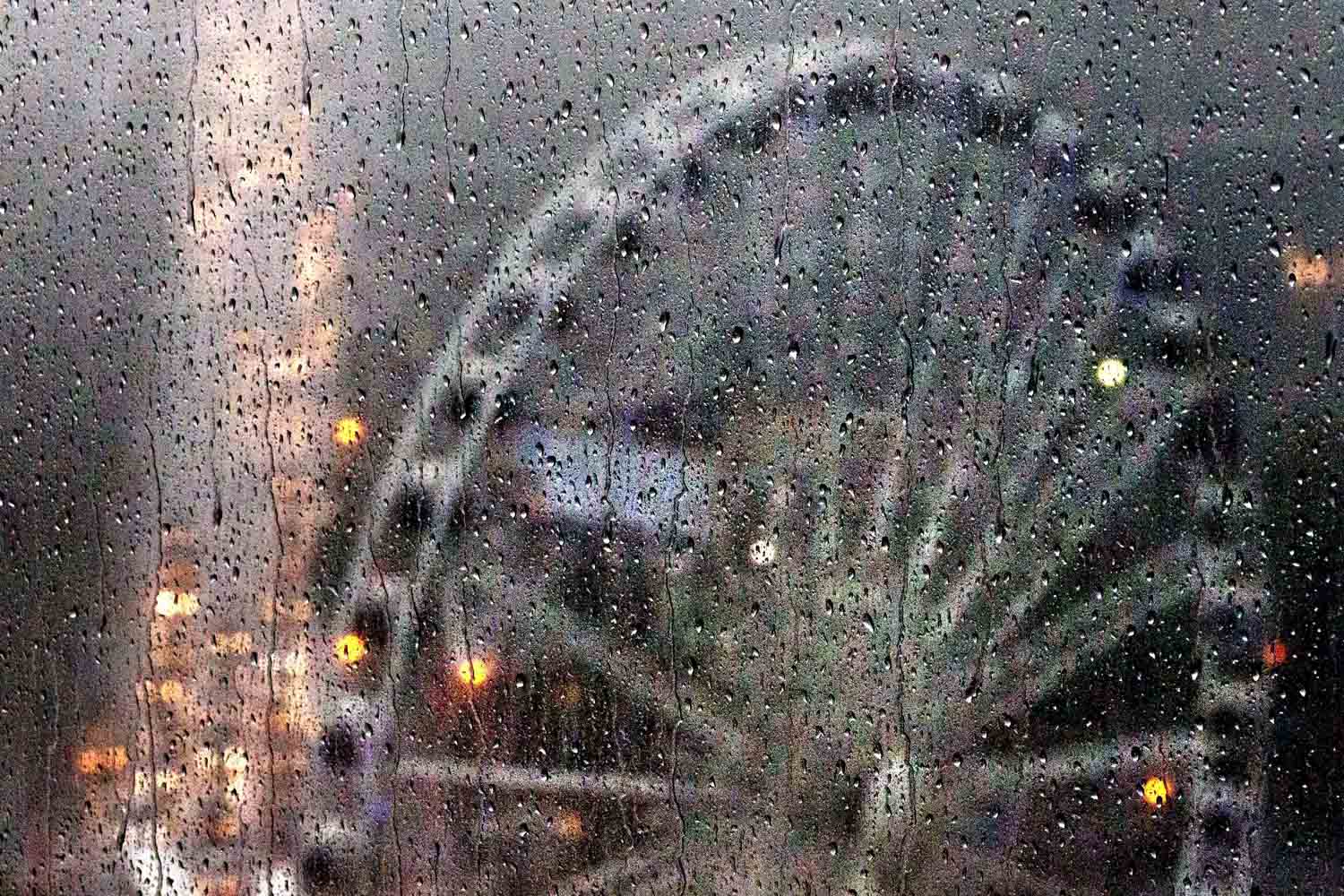 July 17, 2013. Rain drops fall on an office window as heavy rains and high winds pass over the SkyView Atlanta ferris wheel downtown in Atlanta.