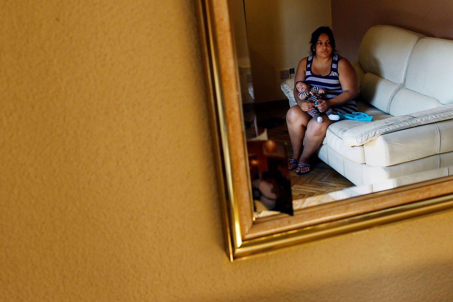 July 1, 2013. Maria Esperanza Flores Mendoza, with her baby as she waits to be evicted in Madrid. The landlord's loss of the apartment to a Ibercaja bank is causing Mendoza's eviction.