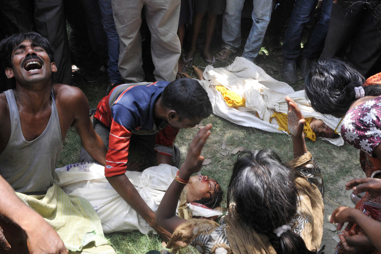 July 17, 2013. Grief-stricken family members react over the bodies of their children who died after consuming a free midday meal at a school at Gandaman in Saran District, India's Bihar state.
