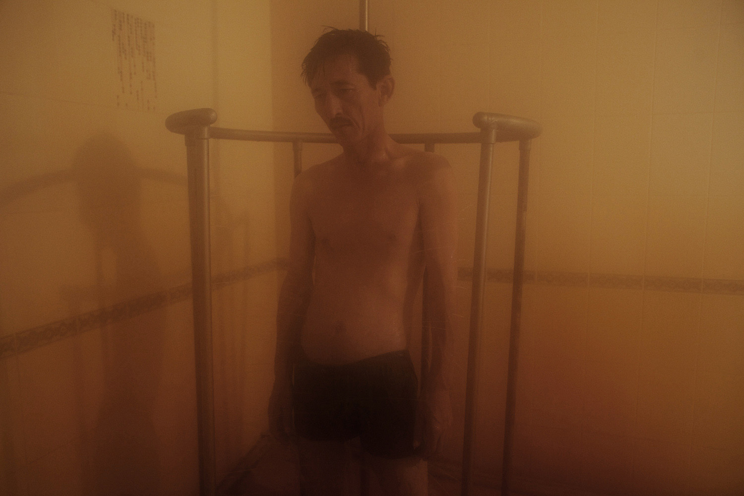 A man from Almaty stands in a shower which sprays water from all sides. It is one of several treatments that patients go through during the course of a day at a spa called Zhetisay Sanatorium in the town of Mineral Water.