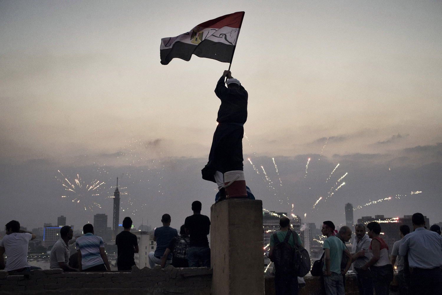 July 3, 2013. A man waves a flag as people rejoice in Tahrir Square.