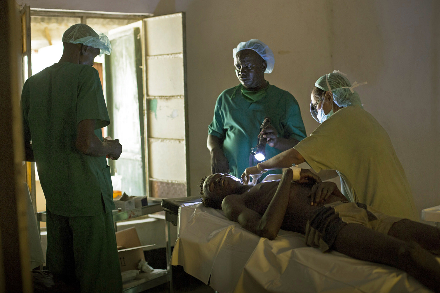 July 15, 2013. Doctors examine a patient in a hospital in Bor, South Sudan, suffering from injuries sustained during tribal clashes that erupted in Jonglei State.