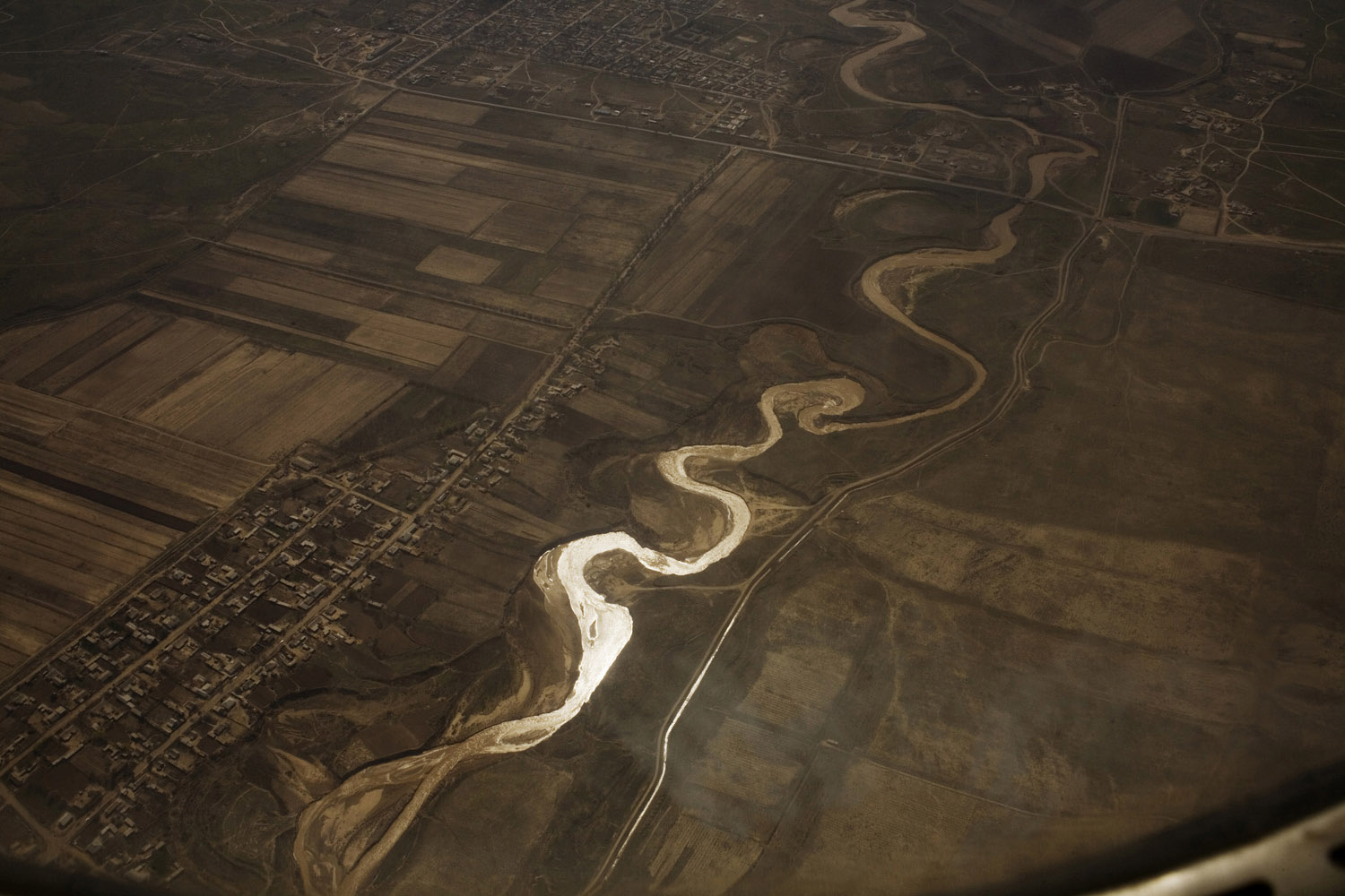 The Syr Darya river near Tashkent, viewed through an airplane window. The river feeds the North Aral Sea, which has grown dramatically since the construction of a dam that now divides the Northern part of the sea (in Kazakhstan) from the southern part (in Uzbekistan).