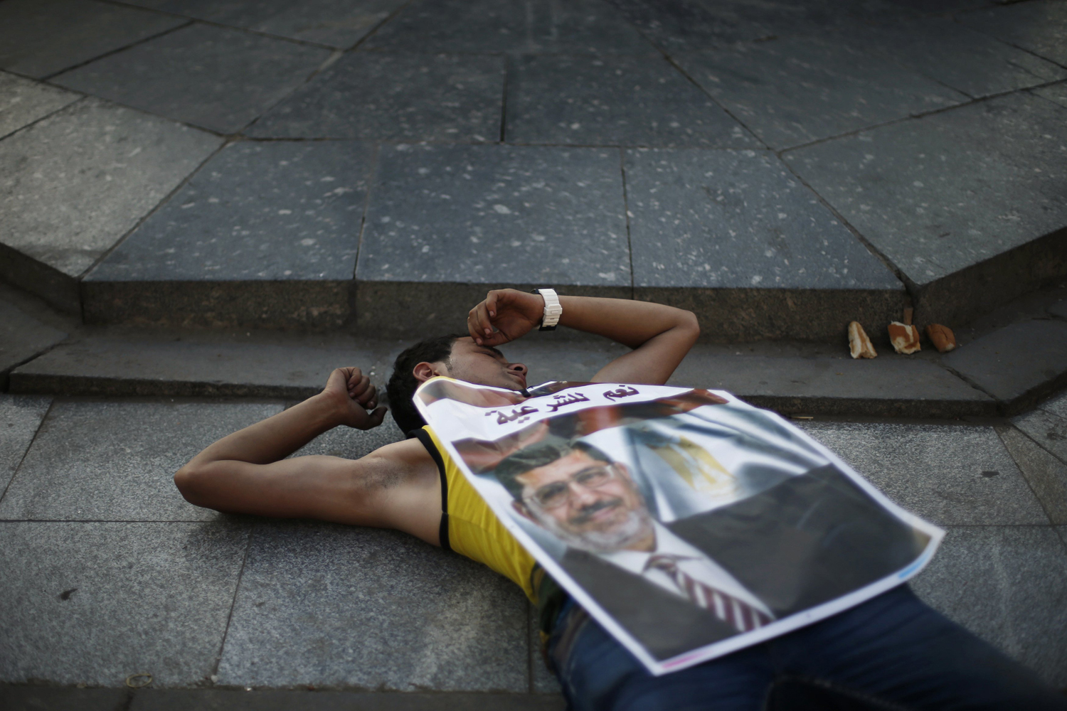 A protester who supports ousted Egyptian President Mursi rests on the ground in Cairo
