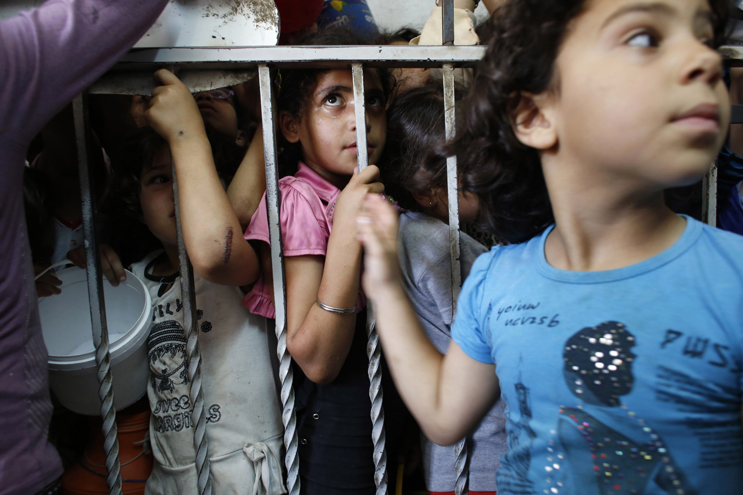 Palestinian children wait to receive food at a soup kitchen in Hebron during Ramadan
