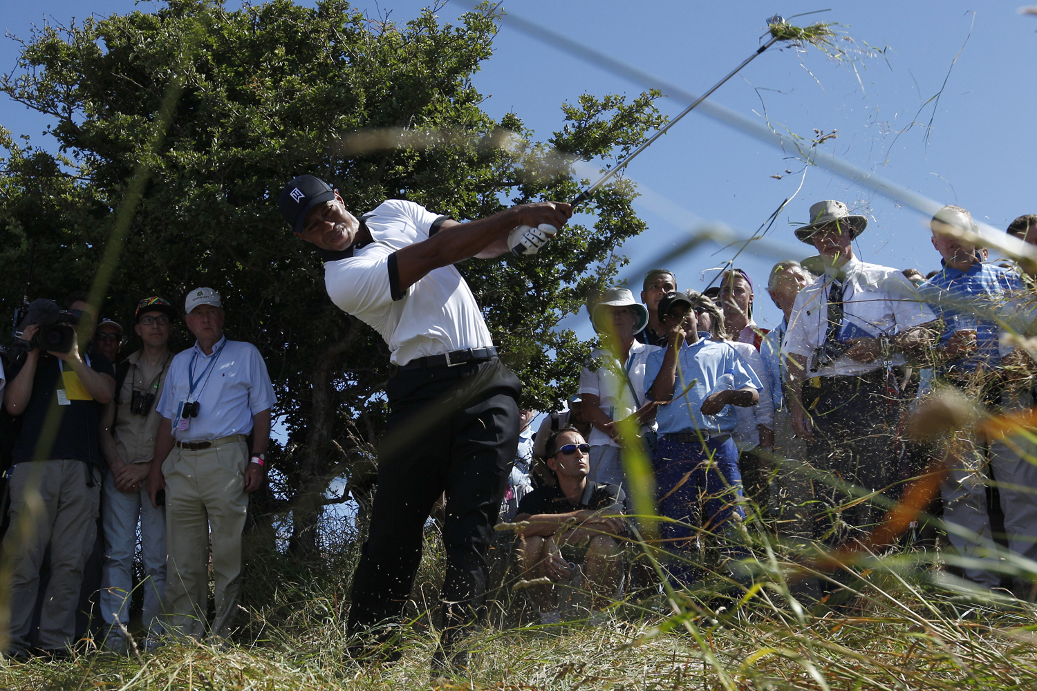 July 18, 2013. Tiger Woods of the United States plays out of the rough on the first fairway during the first round of the British Open Golf Championship at Muirfield, Scotland.