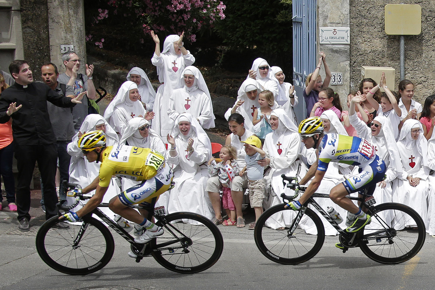 Race leader yellow jersey holder Orica Greenedge team rider Simon Gerrans of Australia cycles past Sisters of the Consolation congregation during the 228.5 km fifth stage of the centenary Tour de France cycling race from Cagnes-Sur-Mer to Marseille