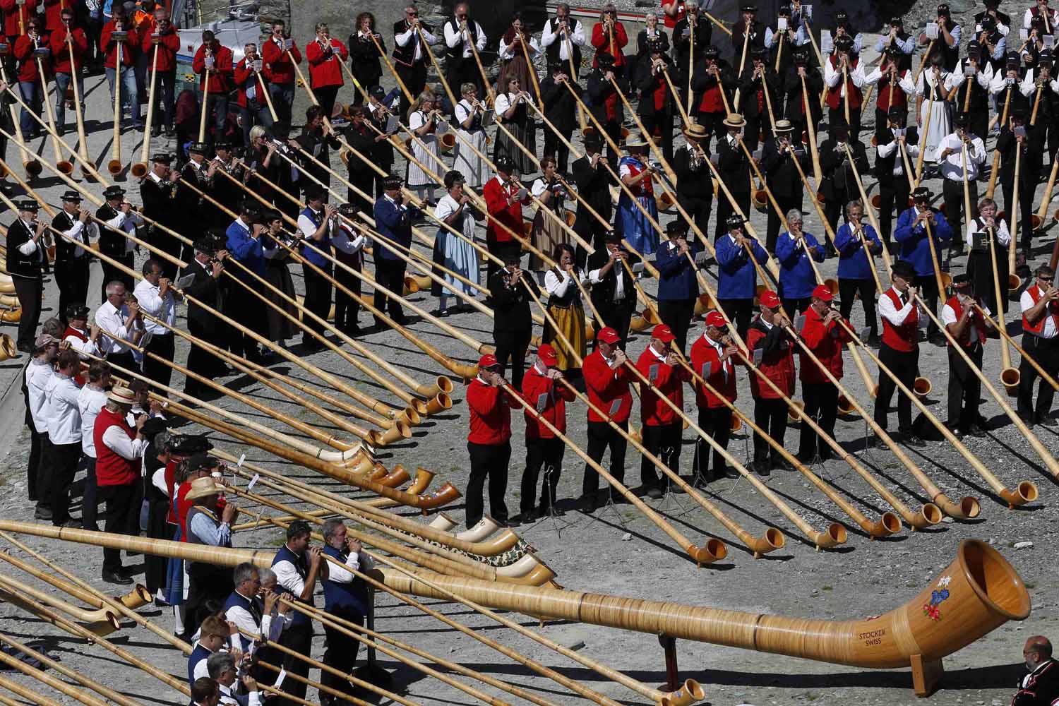 Alphorn players blow their instruments to break the world record for the largest ensemble of people playing the alphorn, on the Gornergrat in front of the Matterhorn mountain near Zermatt