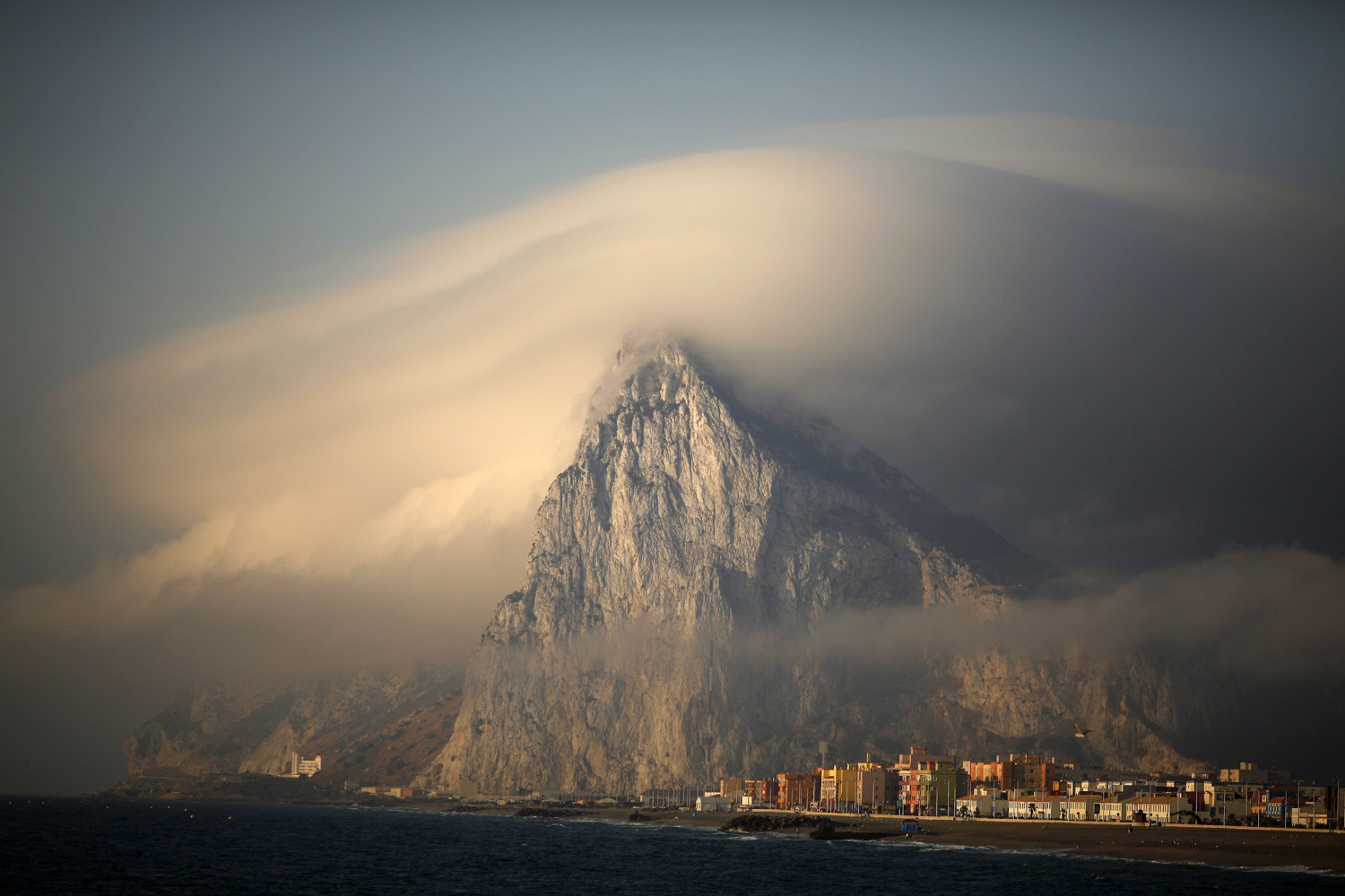 Cloud partially covers Rock of the British territory of Gibraltar at sunrise before Spanish fishermen take part in a protest in Algeciras bay