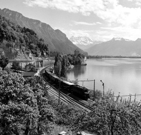 The Simplon-Orient Express alongside Lake Geneva, near historic Chillon Castle.