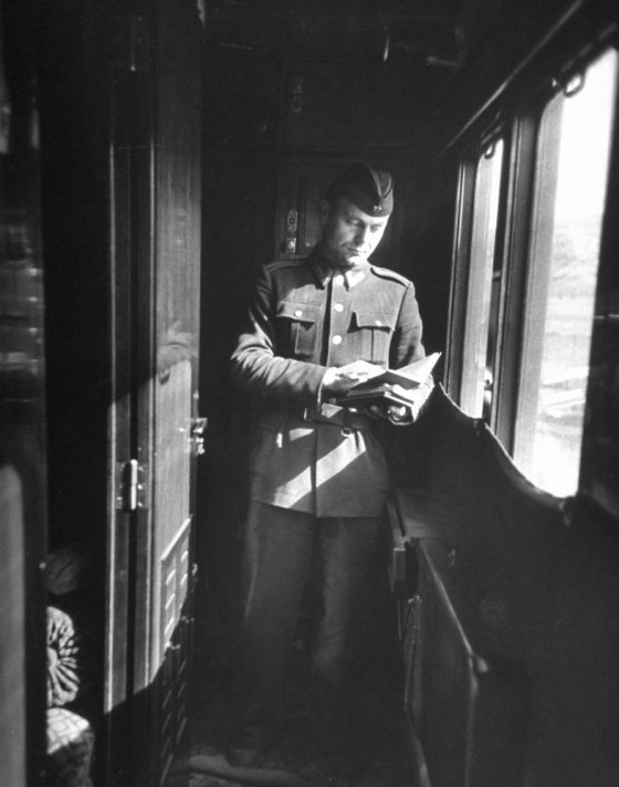 Yugoslav inspector makes a passport check as the train nears Bulgarian border. Like other officials in Yugoslavia he has a quasi-military status.