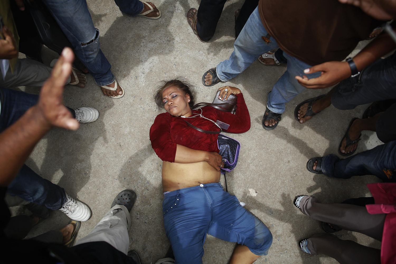July 28, 2013. An election committee official lies unconscious after an angry mob surrounded her in a protest against alleged election irregularities at a polling station in Phnom Penh, Cambodia.