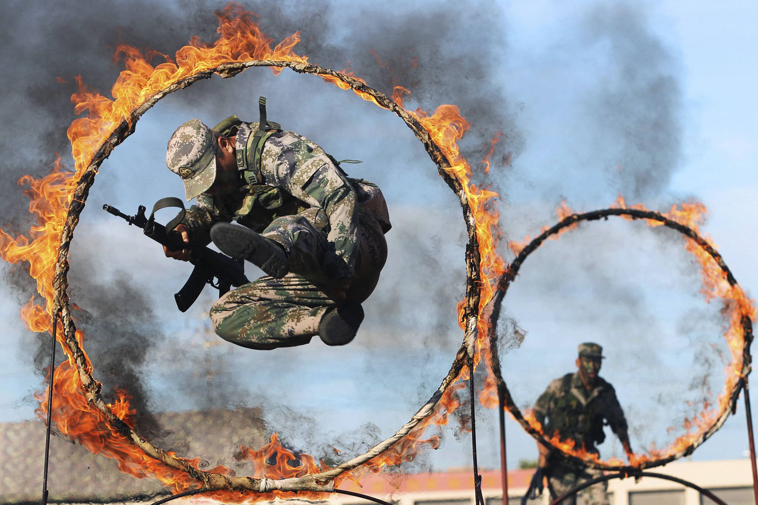 Aug. 1, 2013. A soldier from the People's Liberation Army jumps through a ring of fire as part of training during the PLA Army Day in Wenzhou, Zhejiang province, China.